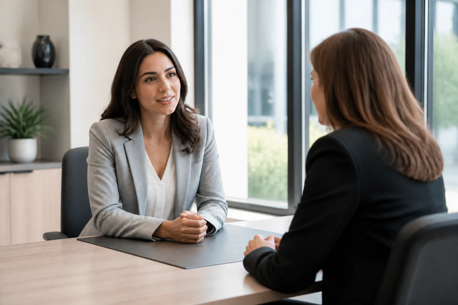 Femme en entretien professionnel avec son manager dans un bureau moderne et lumineux