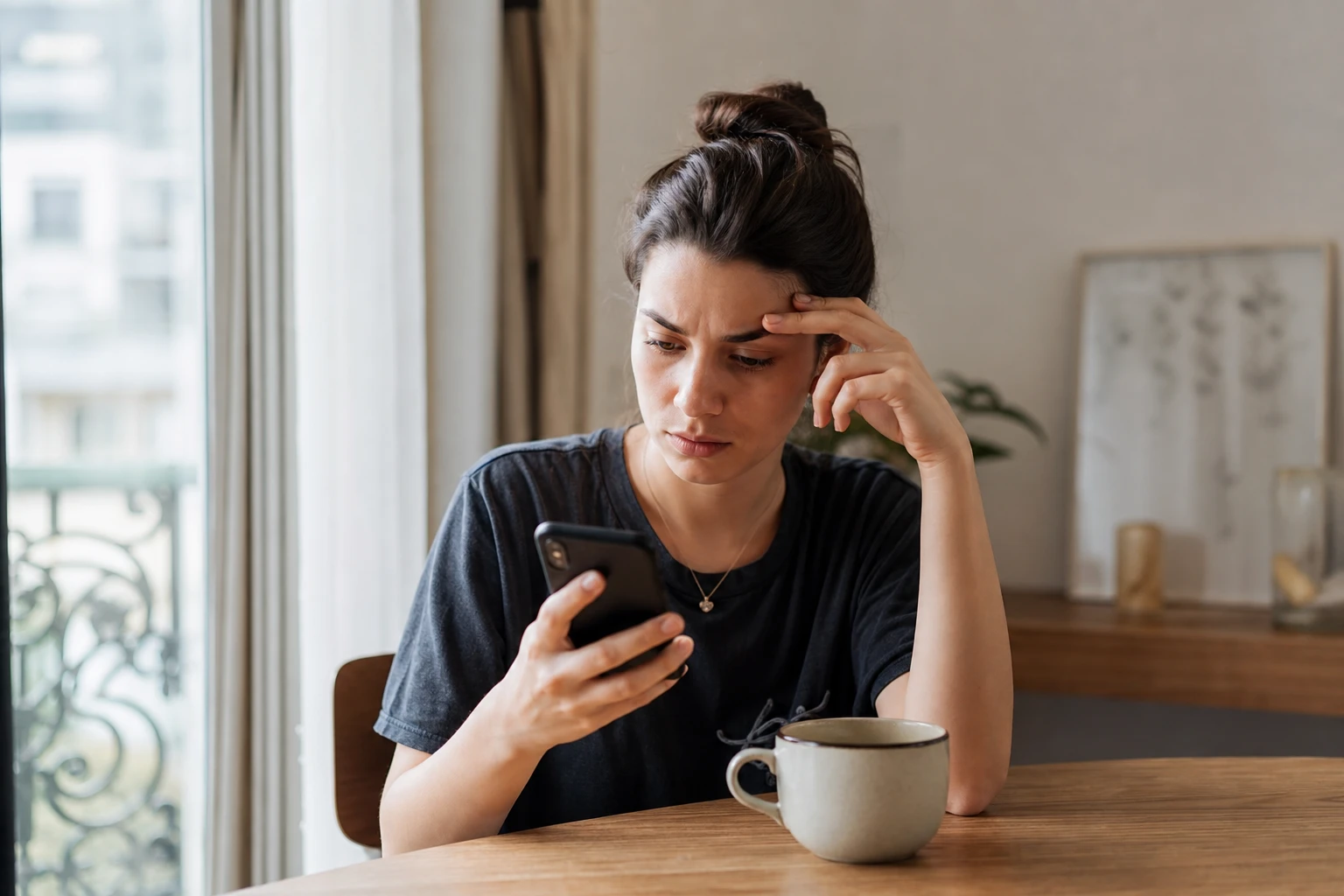 Femme vérifiant les paramètres de son smartphone pour détecter un éventuel espionnage