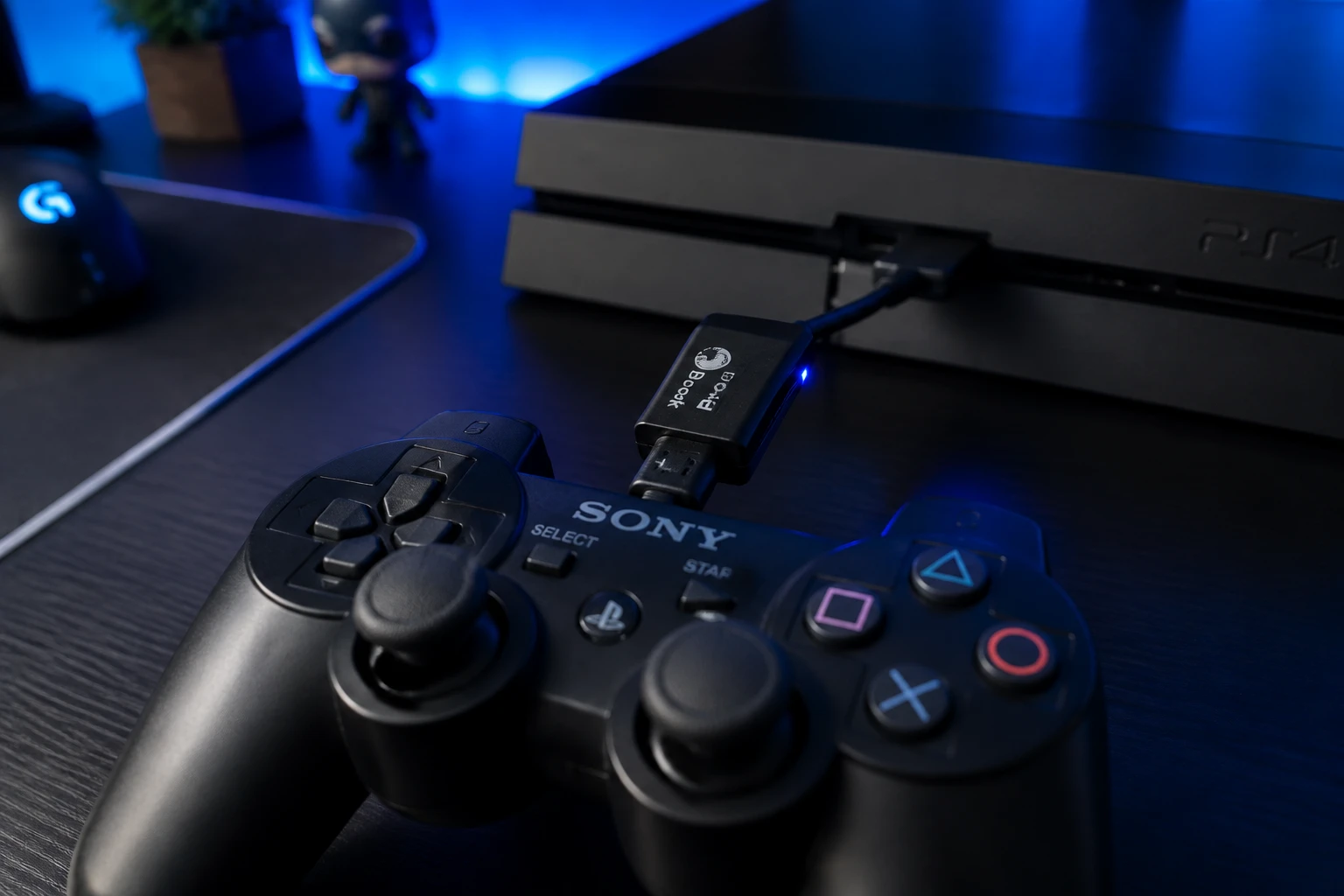 Manette PS3 branchée à une PS4 via un adaptateur Brook Super Converter sur un bureau gaming